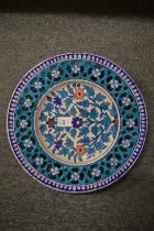 An Iznik style pottery circular dish with pierced border and floral decoration.