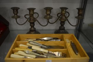 A pair of plated candelabra and various flatware.