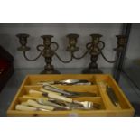 A pair of plated candelabra and various flatware.