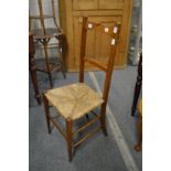 An Arts and Crafts oak and rush seated chair (faults).