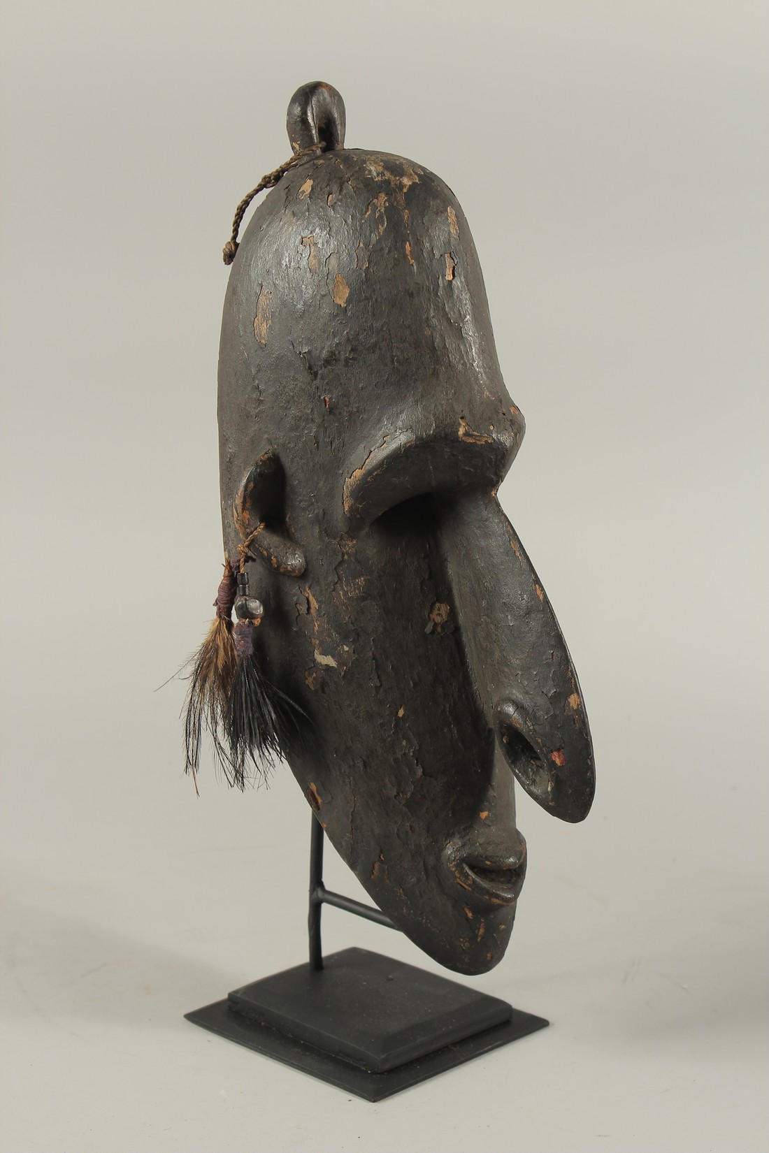 A GOOD CARVED TRIBAL MASK. 15ins high, on a stand.