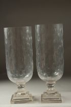 A PAIR OF CUT GLASS HURRICANE LAMPS on square stepped bases.