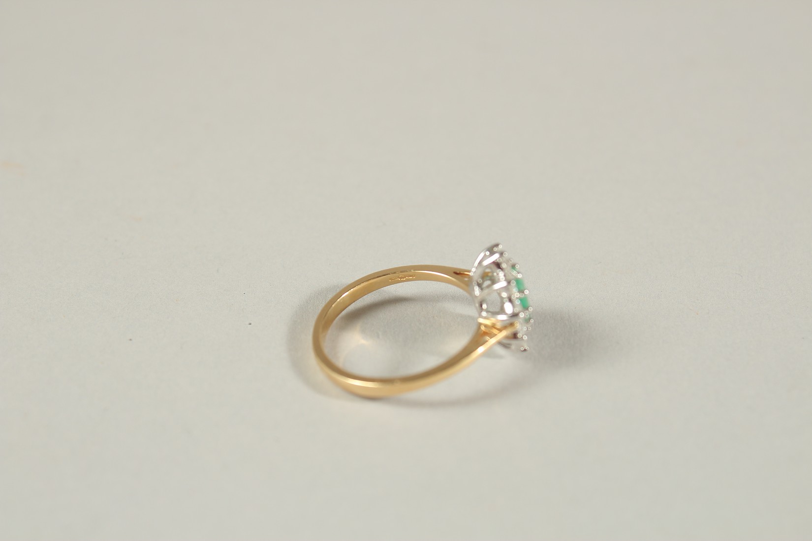 AN 18CT YELLOW AND WHITE GOLD OVAL EMERALD AND RBC DIAMOND CLUSTER RING. Emerald 0.80ct. Diamonds - Image 4 of 6