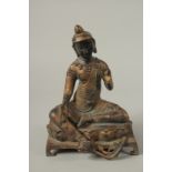 A CHINESE BRONZE SEATED CHINAMAN sitting on a bench. 24cms high.