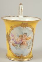 A GOOD DRESDEN CUP with yellow ground, painted with an oval of a cupids. Dresden in gold M.M.S.