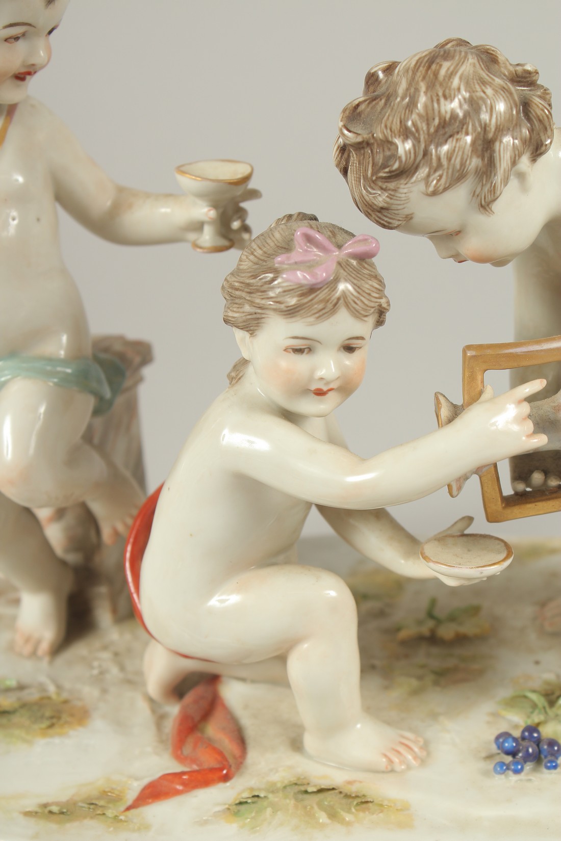 A GOOD PORCELAIN GROUP OF THREE CUPIDS, with a large urn and grapes. 9.5ins long. - Image 3 of 7