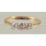 AN 18CT YELLOW AND WHITE GOLD THREE-STONE RBC DIAMOND RING. Diamonds 0.50ct.