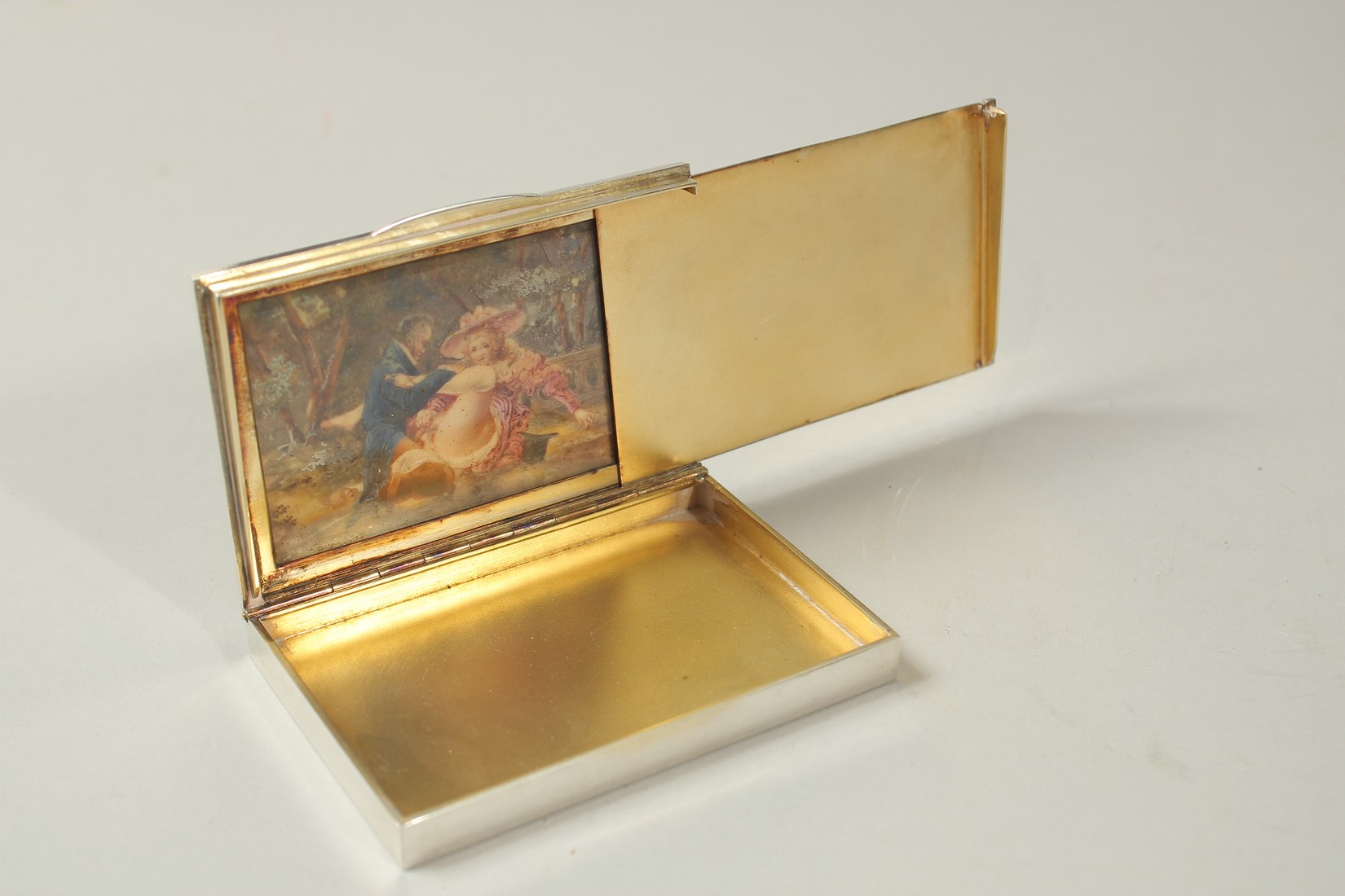 A CONTINENTAL SILVER CIGARETTE CASE with engine turned decoration, the interior of the lid revealing