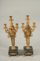 A GOOD PAIR OF EMPIRE DESIGN GILT METAL CLASSICAL CANDLESTICKS on square marble bases. 45cms high,