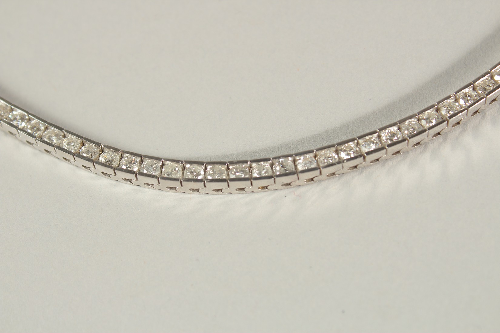 A 14CT WHITE GOLD SEMI-RUBOVER SET RBC DIAMOND LINE BRACELET, with an open blox clasp and safety - Image 4 of 8