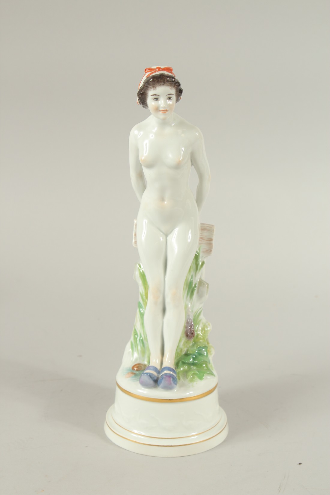 A MEISSEN FIGURE OF A STANDING WOMAN RESTING ON A FENCE. A circle of geese around the base. Modelled