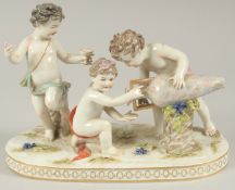 A GOOD PORCELAIN GROUP OF THREE CUPIDS, with a large urn and grapes. 9.5ins long.