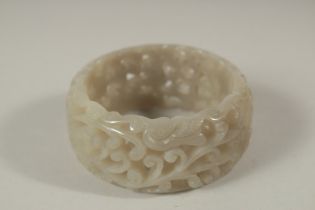 A CHINESE PIERCED JADE BANGLE. 7cms diameter x 3cms deep.