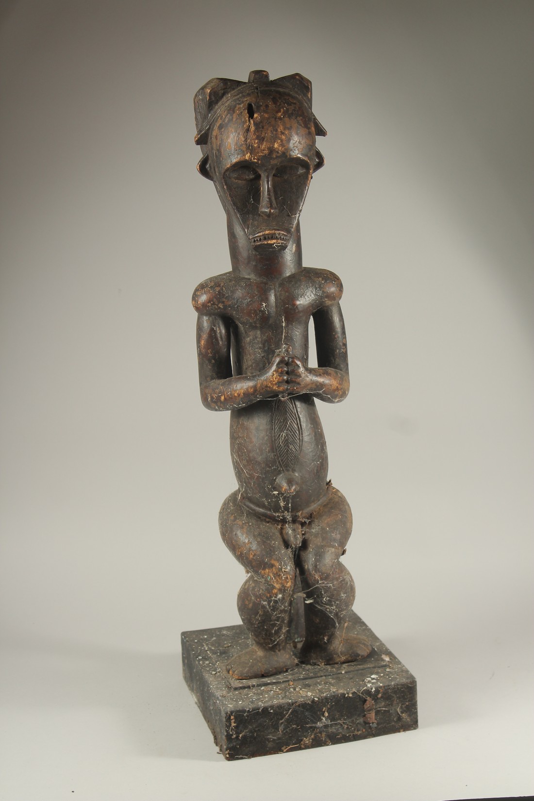 A LARGE CARVED WOOD TRIBAL SEATED FIGURE. 30ins high.