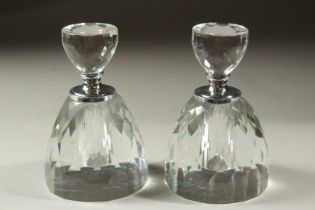 A PAIR OF CUT GLASS CIRCULAR PERFUME BOTTLES AND STOPPERS. 13cms high.