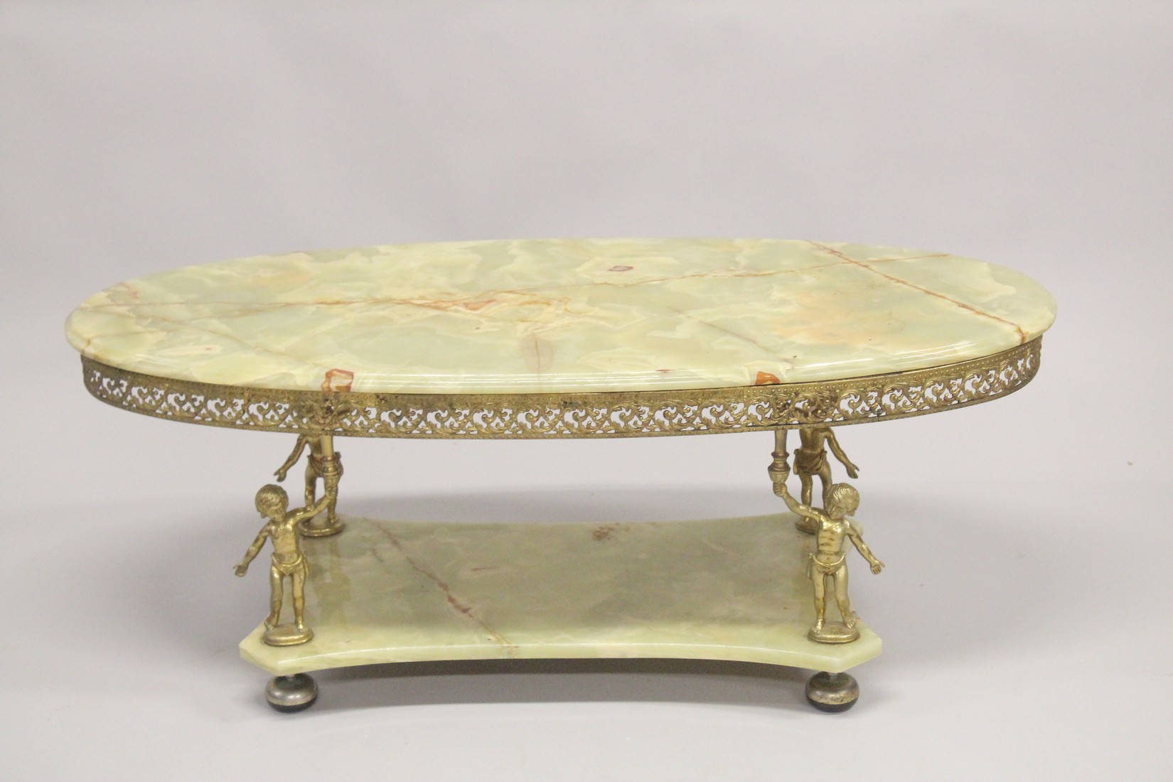 A GOOD ONYX AND GILT METAL OVAL COFFEE TABLE with classical supports and under tier. 4ft long x