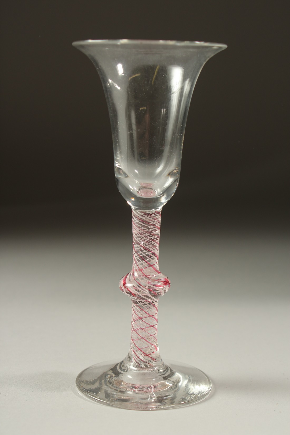 A DUTCH WINE GLASS with inverted bell bowl and coloured twist stem and knop. 6.5ins high.