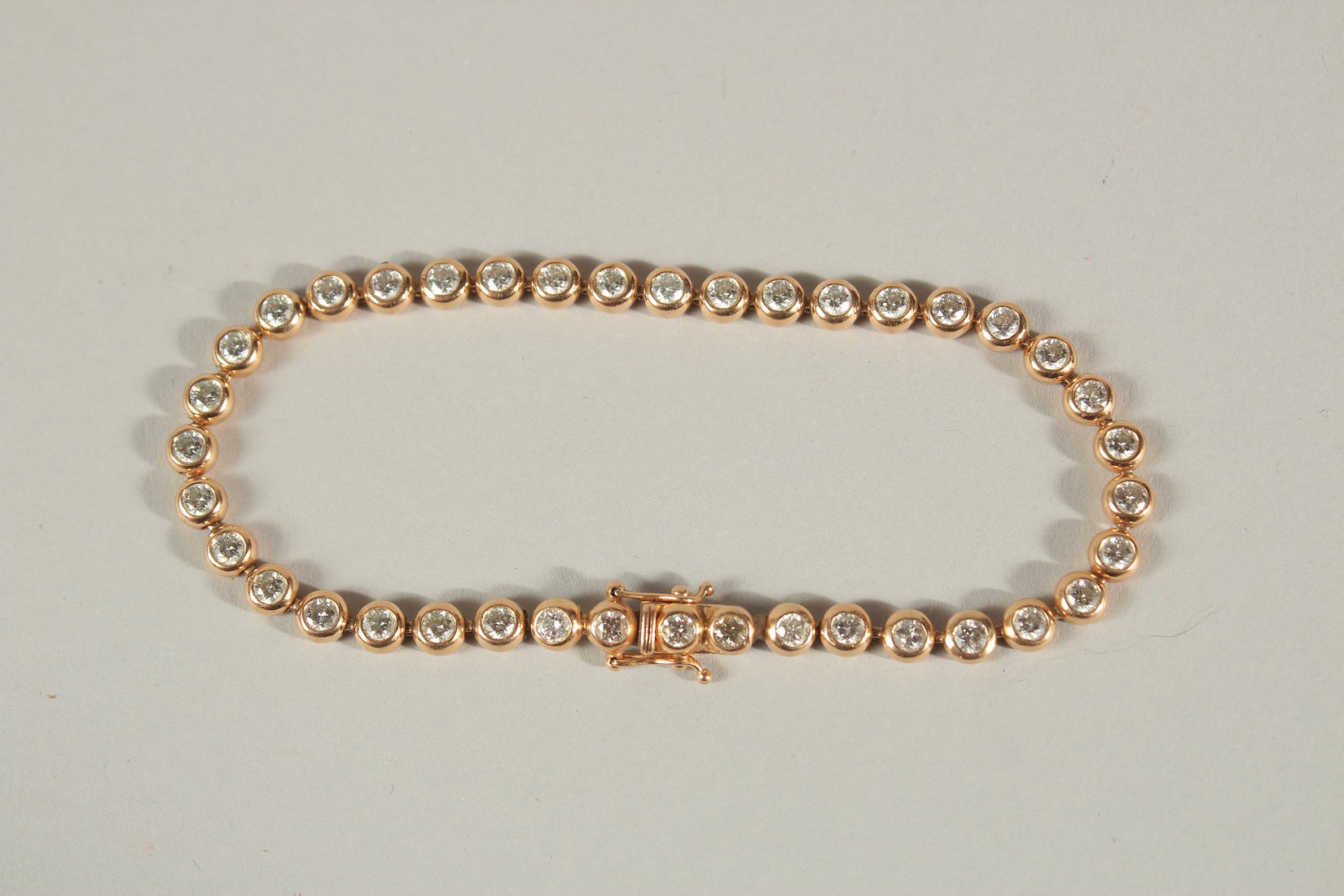 A 9CT ROSE GOLD DIAMOND LINE BRACELET. Approc. 5ct of diamonds.