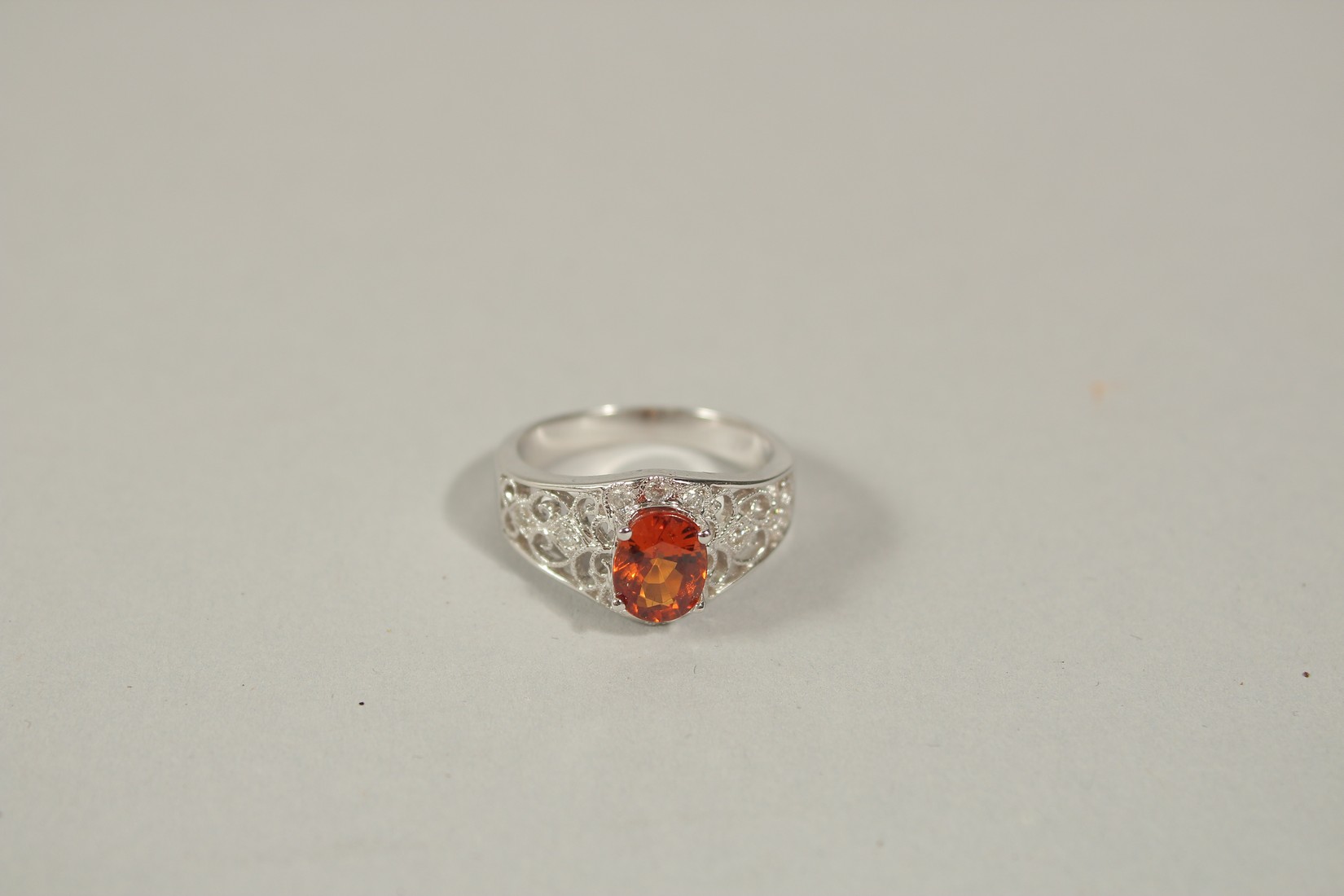 AN 18CT WHITE GOLD, DIAMOND AND ORANGE SAPPHIRE RING, size N.