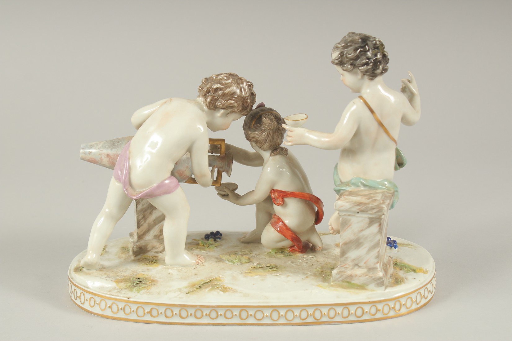 A GOOD PORCELAIN GROUP OF THREE CUPIDS, with a large urn and grapes. 9.5ins long. - Image 5 of 7