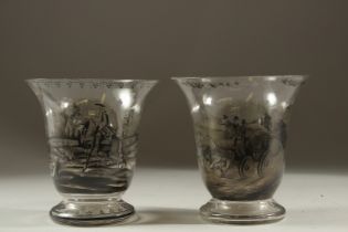 A PAIR OF GLASS VASES WITH COACHING SCENES. 6.5cms high.