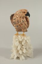 A CARVED STONE EAGLE on a crystal base. 9ins high.