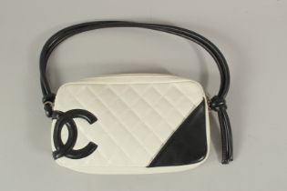 A CHANEL WHITE LEATHER BAG with black CC and handle, with dust cover. 22cms long x 15cms deep.