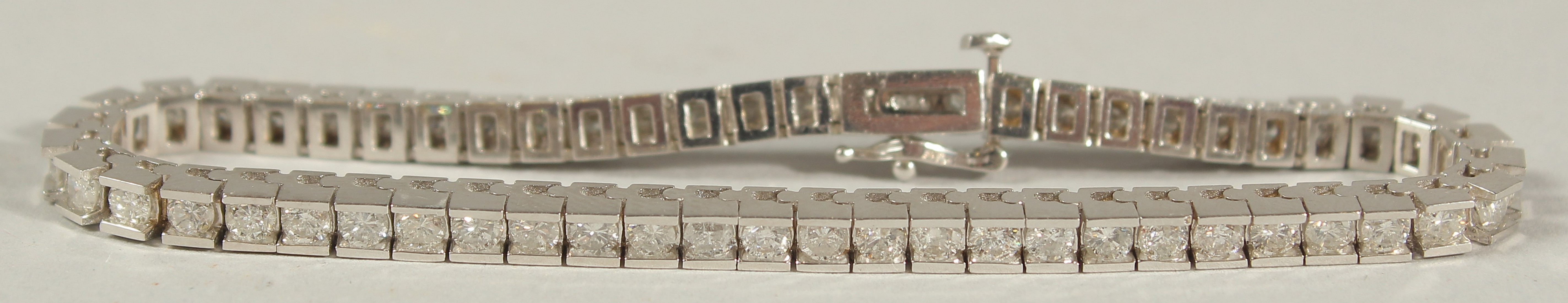 A 14CT WHITE GOLD SEMI-RUBOVER SET RBC DIAMOND LINE BRACELET, with an open blox clasp and safety - Image 8 of 8