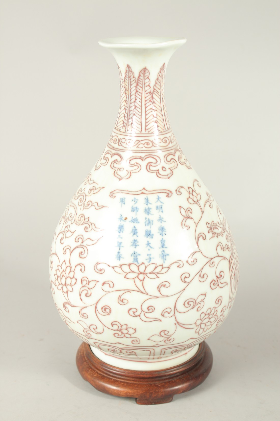 A CHINESE UNDERGLAZE RED AND WHITE YUHUCHUNPIN VASE and wood stand. Vase 30cms high.