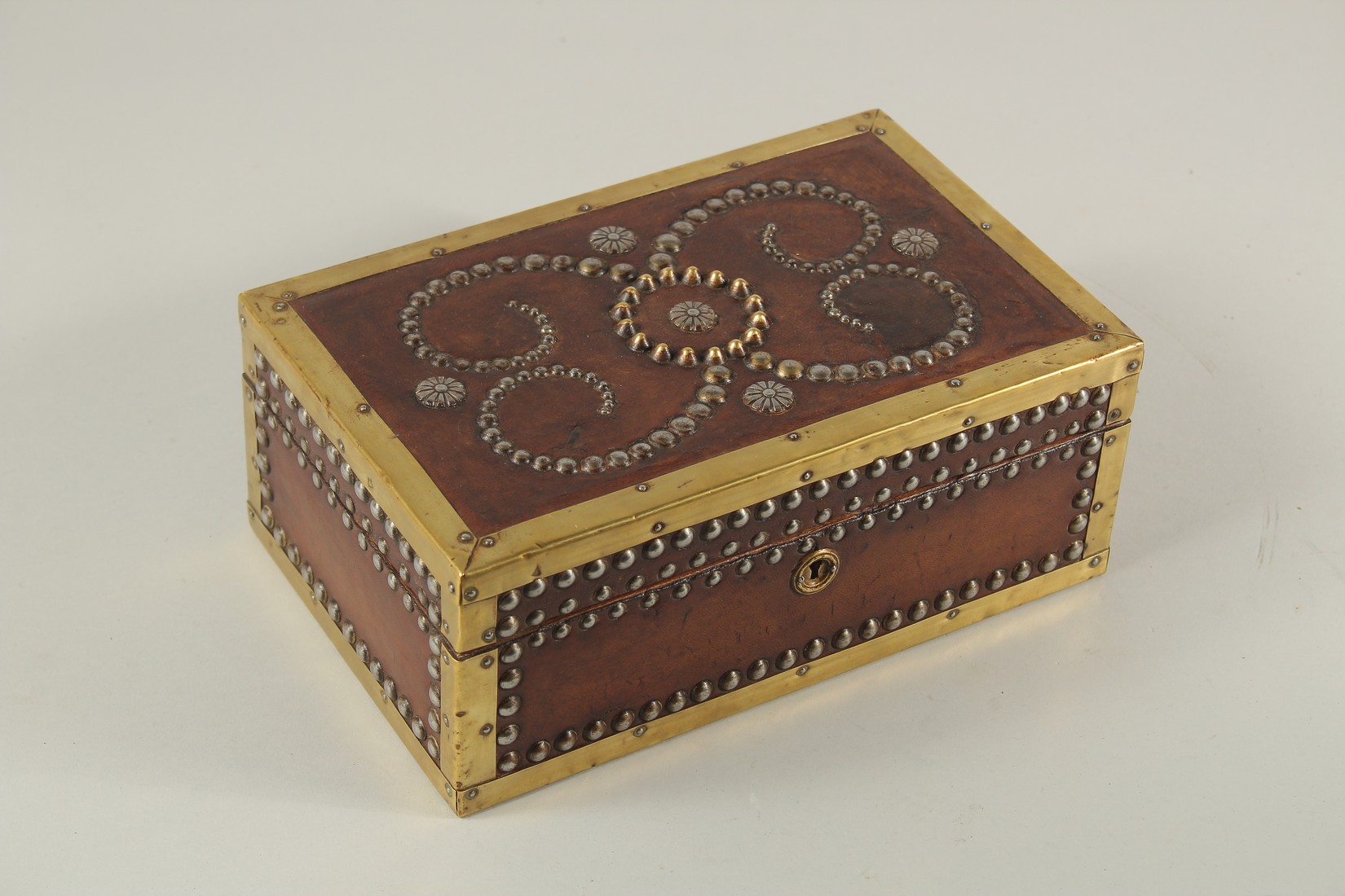 A BRASS BANDED AND STUDDED LEATHER BOX. 10ins long x 4ins high x 6ins deep.