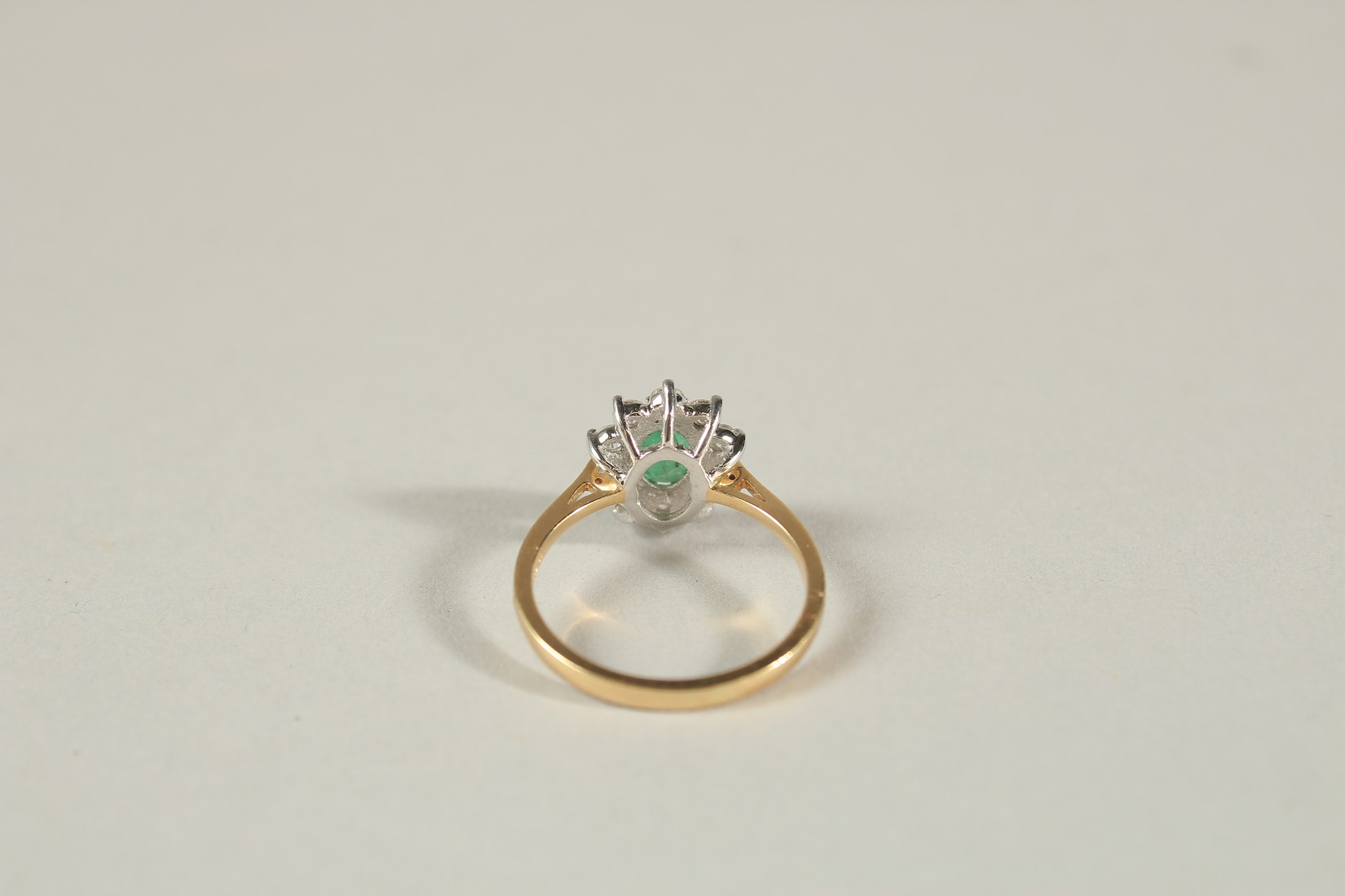 AN 18CT YELLOW AND WHITE GOLD OVAL EMERALD AND RBC DIAMOND CLUSTER RING. Emerald 0.80ct. Diamonds - Image 3 of 6