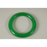 A CHINESE APPLE GREEN JADE BANGLE. 8cms diameter.