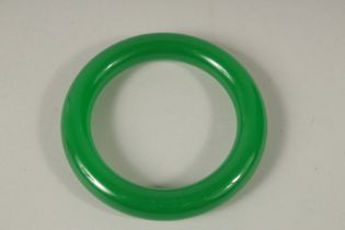 A CHINESE APPLE GREEN JADE BANGLE. 8cms diameter.