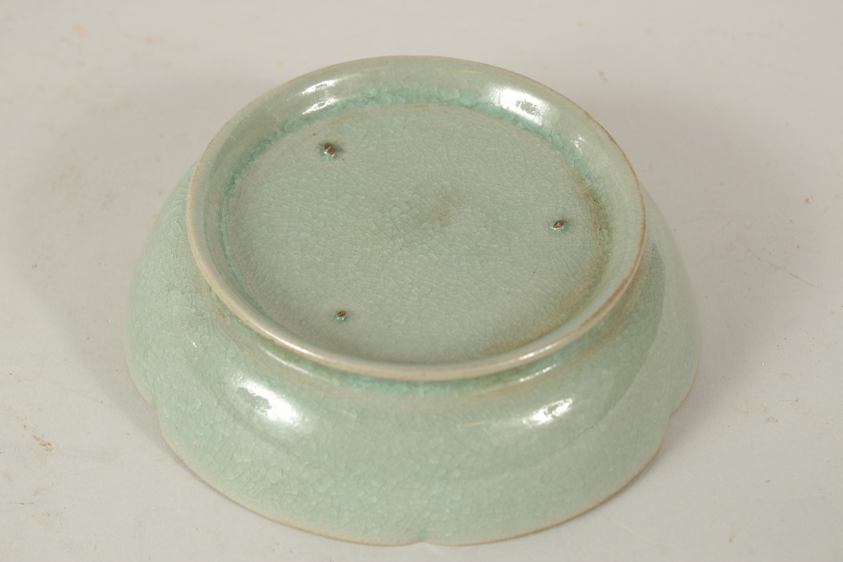 A CHINESE CELADON GLAZE PETAL FORM DISH. 14.5cms diameter. - Image 2 of 2