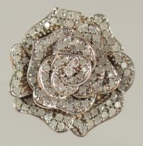 AN 18CT GOLD AND DIAMOND FLOWER RING.