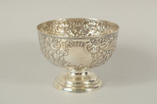 A VICTORIAN CIRCULAR ROSE BOWL with repousse decoration. 6ins diameter. Chester 1897.