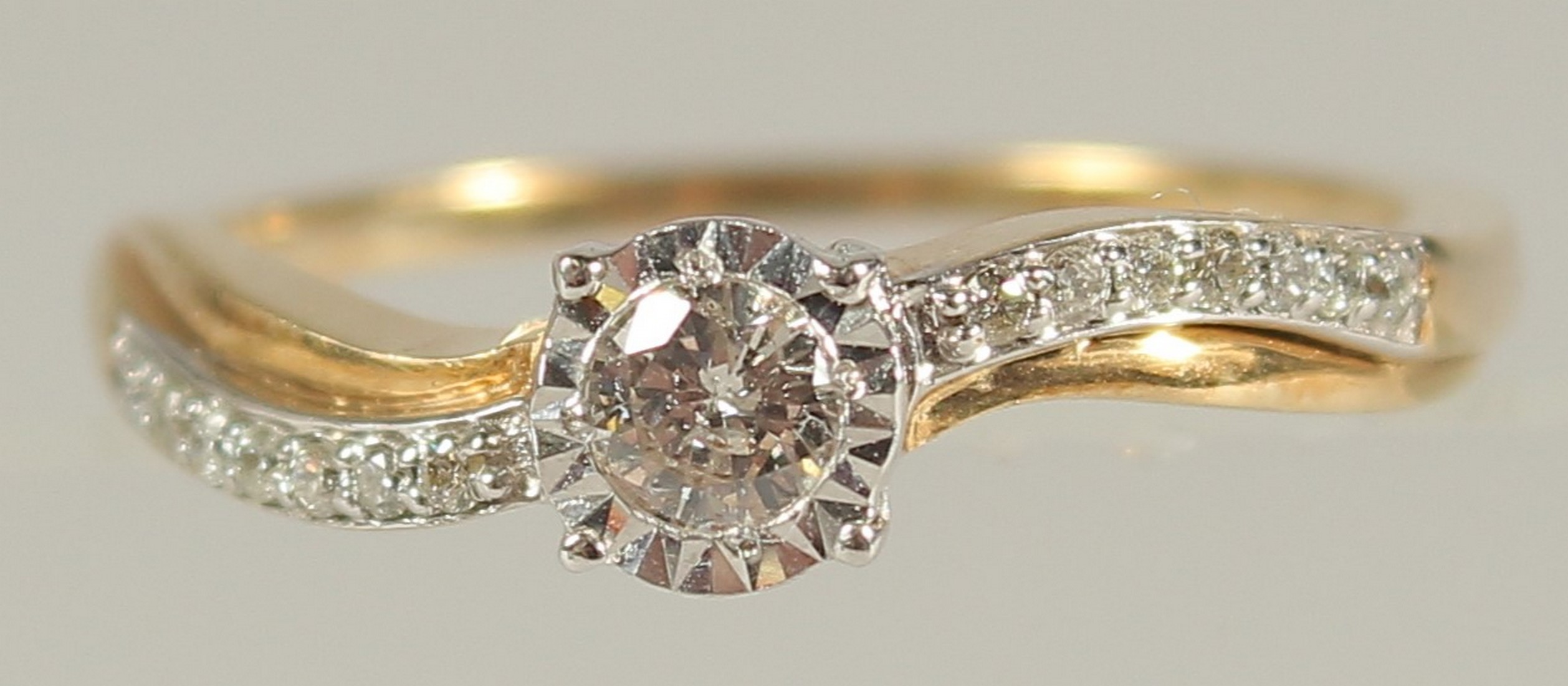 A 9CT YELLOW GOLD SOLITAIRE-STYLE RING SET WITH 0.22 RBC DIAMONDS IN TOTAL, in a twist-style
