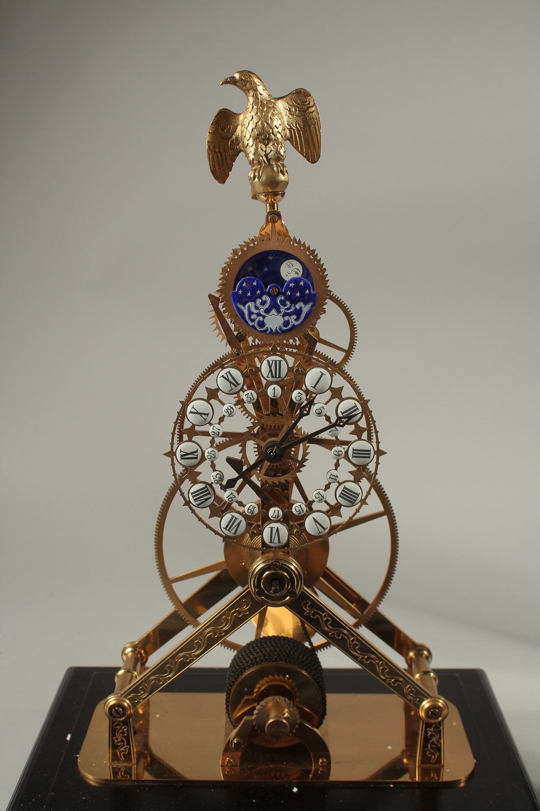 A MOONPHASE BRASS SKELETON CLOCK with eagle, in a glass case. 42cms high. - Image 2 of 3