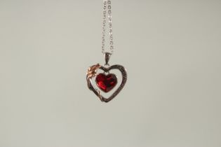 A SILVER HEART PENDANT AND CHAIN in a box.