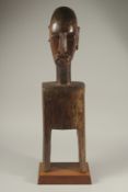 A LARGE TRIBAL CARVED WOOD BUST on a stand. 27ins high.