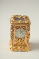 A CAST GILT MINIATURE CARRIAGE CLOCK with female figures.