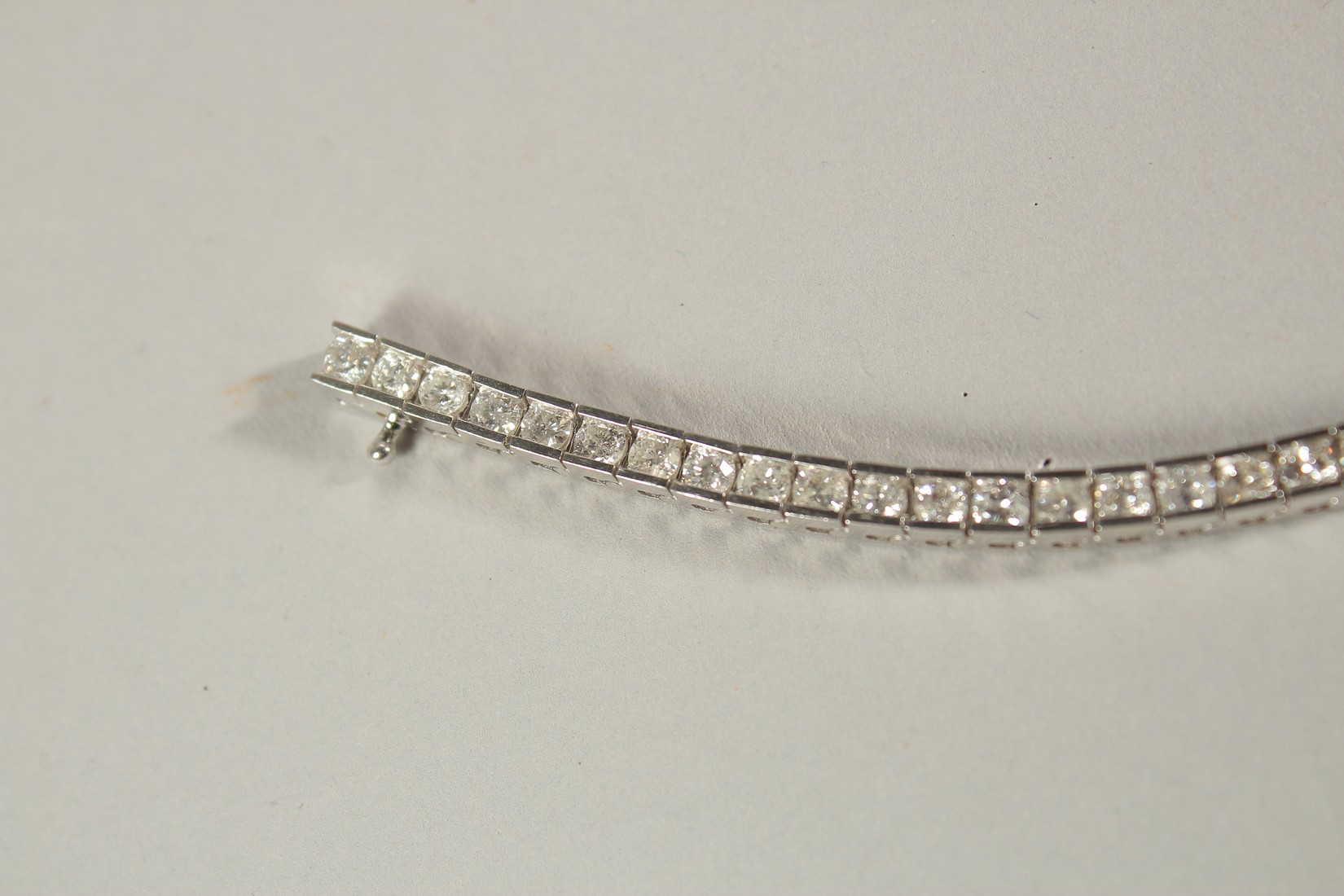 A 14CT WHITE GOLD SEMI-RUBOVER SET RBC DIAMOND LINE BRACELET, with an open blox clasp and safety - Image 6 of 8