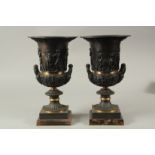 A VERY GOOD PAIR OF CLASSICAL BRONZE TWO HANDLED URNS on square bases. 36cms high.