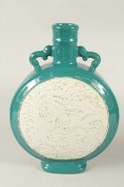 A CHINESE TURQUOISE GLAZE CARVED DRAGON AND PHOENIX MOON FLASK, the base with character mark. 34.