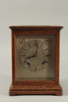 A 1920'S OAK BRACKET CLOCK with silvered dial, silent and chime action, with glass panel sides.