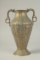 A GOOD ISLAMIC ENGRAVED BRASS TWIN HANDLE VASE, with panels of finely engraved floral decoration.