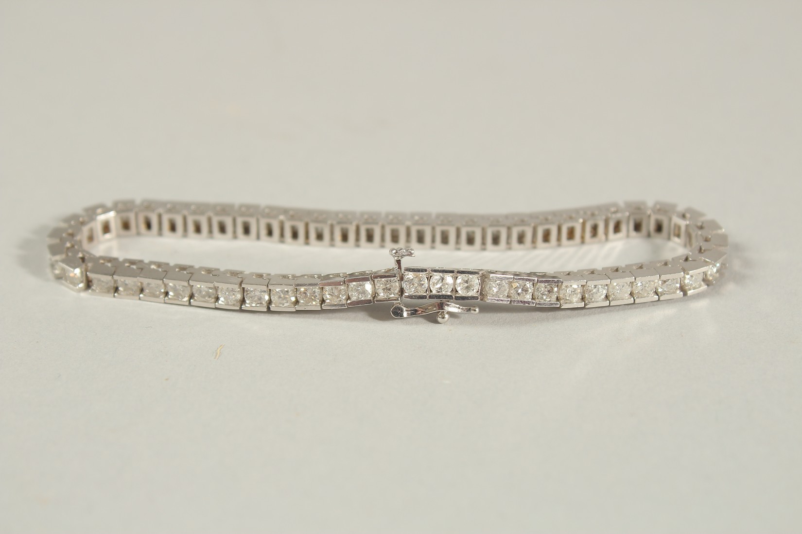 A 14CT WHITE GOLD SEMI-RUBOVER SET RBC DIAMOND LINE BRACELET, with an open blox clasp and safety - Image 7 of 8
