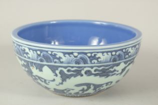 A CHINESE BLUE GROUND PORCELAIN BOWL, with incised white dragons. 26.5cms diameter.