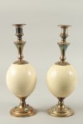 A GOOD PAIR OF OSTRICH EGG AND BRASS CANDLESTICKS BY GARRARD & CO., LONDON. The brass inset with