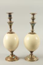 A GOOD PAIR OF OSTRICH EGG AND BRASS CANDLESTICKS BY GARRARD & CO., LONDON. The brass inset with